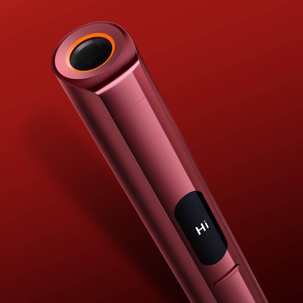 A sleek, red electronic device with a digital screen displaying the word Hi, set against a red gradient background. The device has a circular opening surrounded by an orange ring at one end.