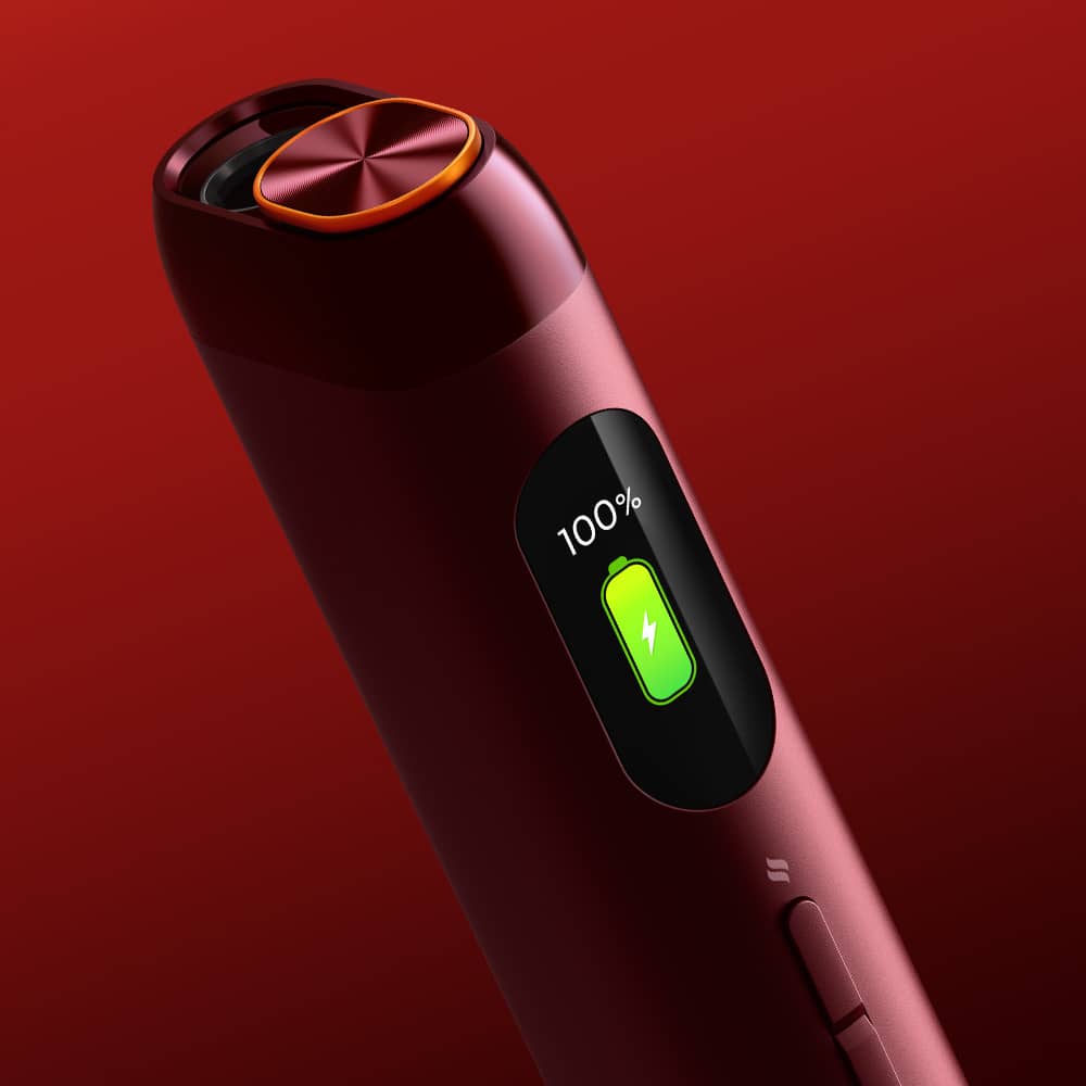 A close-up of a sleek, red electronic device with a digital display showing a 100% battery charge and a green charging icon, set against a red gradient background.