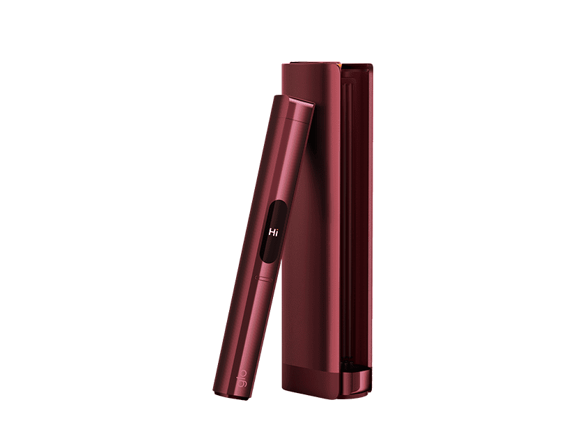 The glo™ HILO Plus, a sleek dark red device with a small display showing “Hi,” stands beside its matching rectangular case on a simple, light background.